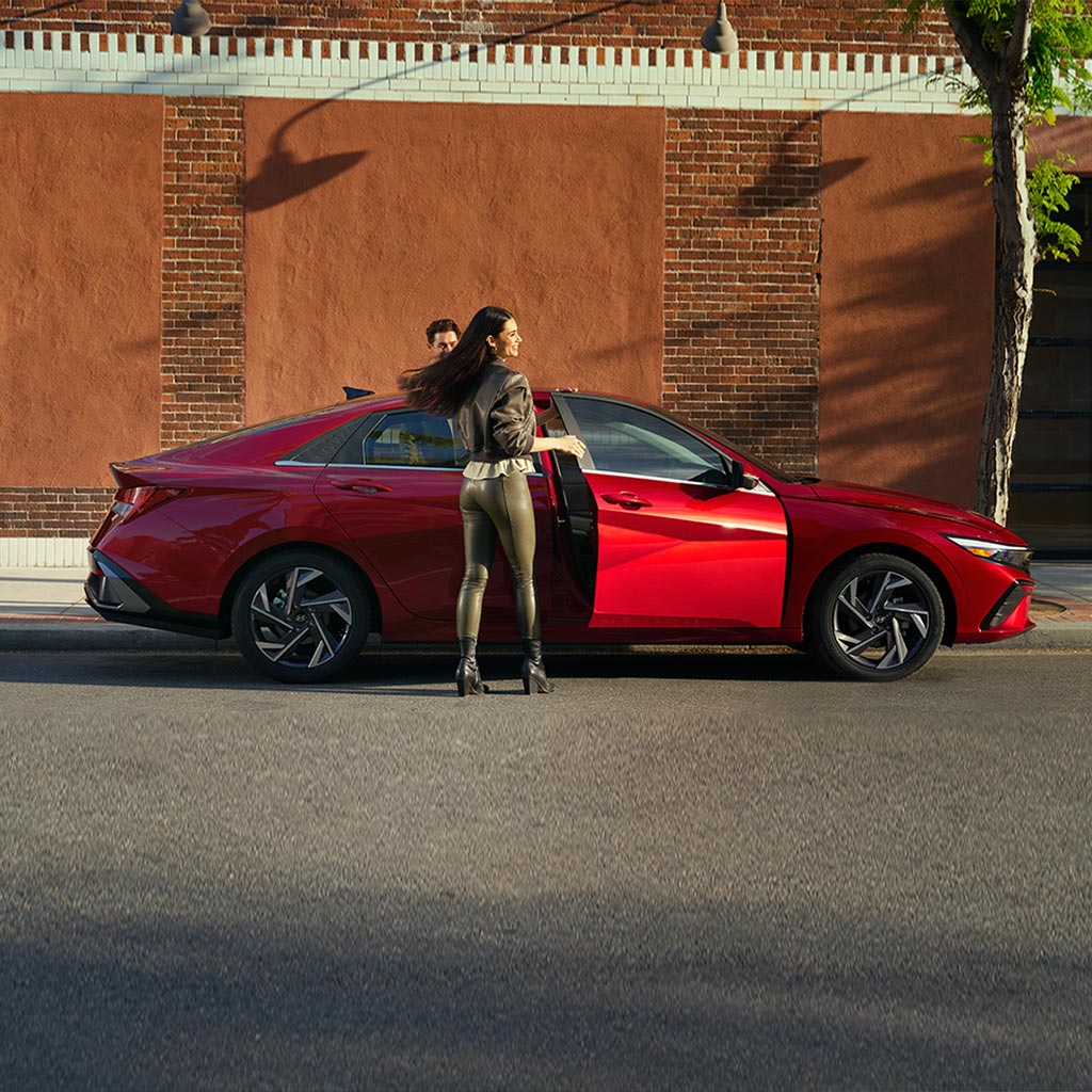 Mujer subiendo al nuevo Elantra en color rojo