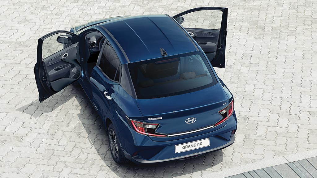 Vista aérea de Hyundai Grand i10 Sedán color azul con puertas delanteras abiertas