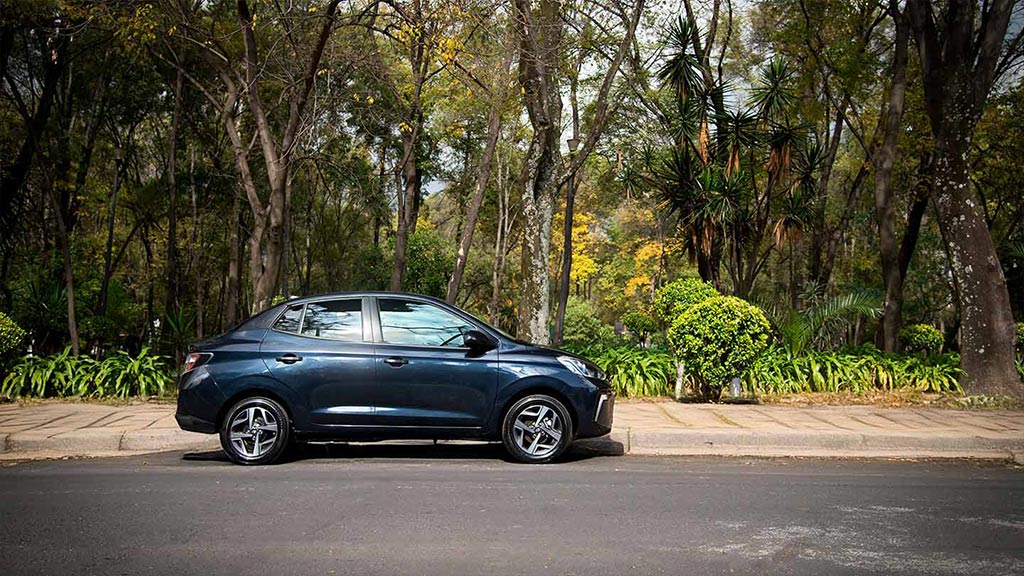 Hyundai Grand i10 Sedán color azul estacionado junto a un parque