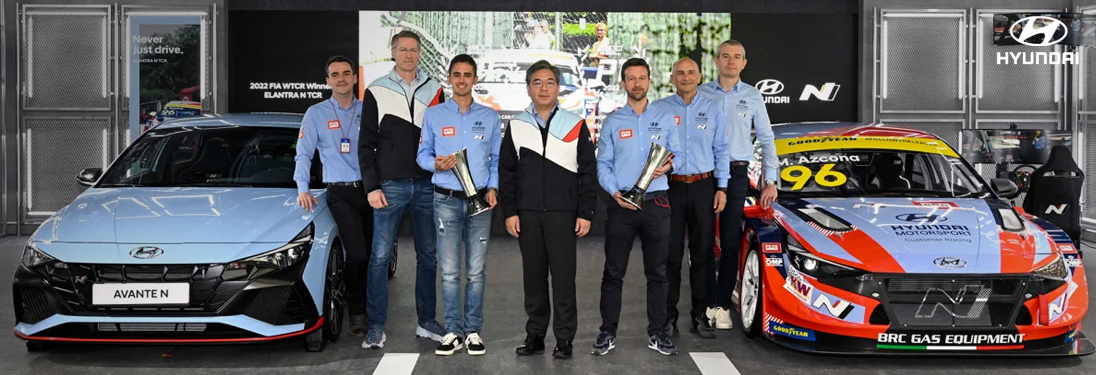 Empleados de Hyundai junto a vehículos N mostrando trofeos